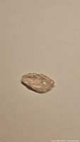 Single natural untreated light champagne morganite crystal shown on plain background, small size, approximate 6 carats.