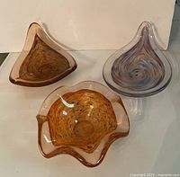 All three art glass bowls shown together on white background displaying their diverse shapes and colors.