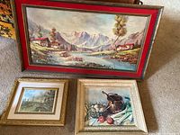Overall view of three framed art prints showing the large landscape with velvet border and two smaller prints.