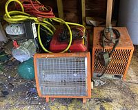 Photo showing a western gas generator in red, a green air compressor with yellow and red hoses, and two orange General Electric heaters with metal grills.