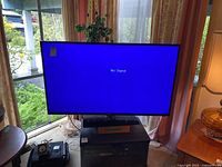 Front view of powered on Hisense TV displaying 'No Signal' blue screen.
