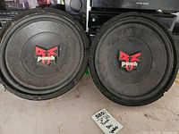 Front view of two 12 inch Punch speakers with red and black Punch DVC logo on cones. Speakers show dust and surface wear.