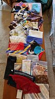 Full view of all arranged scarves on a table showing various colors and patterns.
