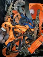 Close up of multiple tie downs in various colors and metal hardware.
