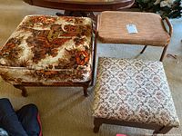Three vintage stools grouped together showing floral tapestry storage stool, beige-brown woven fabric stool, and floral patterned fabric stool.