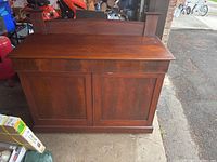 Full front shot of the wooden buffet cabinet showing top, doors, and base.
