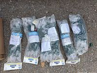Top view of six sealed bags of commercial string lights with visible packaging labels and green cords.