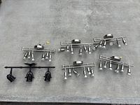 Overview of six mixed light fixtures on a gray floor including silver and brown track lights.