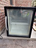 Front view of the Minus Forty under counter freezer showing black frame and glass door with wire shelf inside.