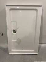 Top view of white rectangular shower base showing recessed interior and drain hole.