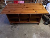 Front view of wooden table showing top and two rows of open shelves