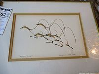 Framed picture of the artwork showing the full image with several stylized birds in flight created with black and gold lines.