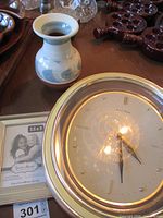 Photo of ceramic vase, Daniel Dakota clock, and photo frame on table