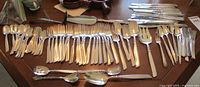 Full view of the South Seas Community silverplate flatware spread on a table showcasing the variety of knives, forks, spoons, and serving utensils.