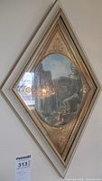Full view of the vintage diamond-shaped framed artwork showing the gold ornate frame and the classical ruin scene in an oval print.