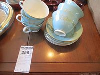 Six Royal Doulton Melrose cups stacked with matching saucers on a table