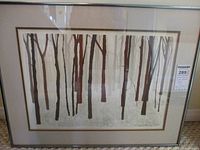 Photo of the framed lithograph showing the full artwork depicting tree trunks in a winter scene, signed and numbered in pencil below the image.