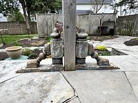 Photo showing both corbels placed on patio floor, capturing their full profile and size in a garden setting.
