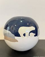 Front and side view showing rounded ceramic vessel with polar bear design and dark blue top section.