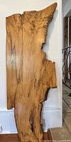 Full view of the tall, irregularly shaped live edge wood slab showcasing its smooth finished surface and natural grain patterns.