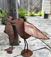 All three rusted steel bird sculptures together, showing scale and arrangement