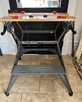 Front view of the vintage Black & Decker Workmate workbench showing metal frame and wooden top panels with clamps