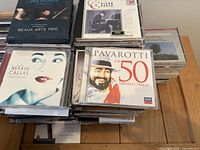 Top view of stacked classical music CDs showing Maria Callas, Luciano Pavarotti, Beaux Arts Trio, Glenn Gould covers.