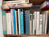 Books arranged on a shelf including notable titles such as Crime and Punishment by Dostoevsky and works by Aldous Huxley and Lawrence Durrell.