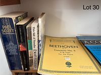 Books and sheet music standing vertically on a shelf, titles visible include Beethoven, Paul Scott, and others.