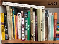 Books arranged on a wooden bookshelf showing travel, poetry, and reference titles