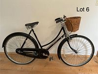 Full profile of bicycle showing frame, chain guard, saddle, mudguards, and front basket