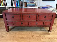 Full front view of red console table showing six drawers and overall form