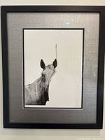 Framed black-and-white horse print by Von with linen-textured mat and black wood frame.