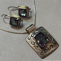 Top view of necklace pendant and matching earrings with iridescent square gemstones set in sterling silver