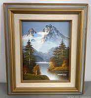 Framed oil painting showing a mountain scene with lake and trees, signed Marklein.