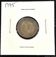 Obverse side of the 1945 Canadian 1 cent coin featuring King George VI portrait, mounted in a white cardboard holder stapled on edges.