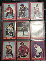 Front view of nine 1973-74 O-Pee-Chee NHL trading cards in protective sheet showing various players with red border design.