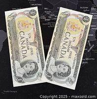 Top view of two consecutive 1973 Canadian one dollar banknotes front side featuring Queen Elizabeth II.