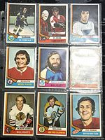 Front view of nine vintage 1974-75 O-Pee-Chee NHL hockey cards featuring various players from teams such as Sabres, Flyers, Blues, Scouts, Maple Leafs, Black Hawks, Bruins, Red Wings.