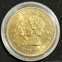 Obverse side of gold-colored 1984 Ontario Royal Visit medal featuring portraits of a royal man and woman with inscriptions in English and French.