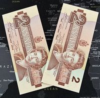 Two consecutive 1986 Canadian 2 dollar banknotes showing front side with portrait of Queen Elizabeth II in brown-red tones.