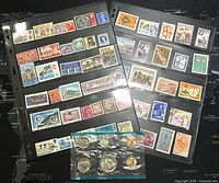 Two black binder pages containing over 100 assorted postage stamps in plastic sleeves, varied themes and colors.