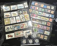Two plastic sheets containing over 100 assorted international and Canadian stamps displayed, along with several coins in protective sleeves positioned below them.