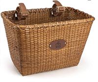 Rectangular handmade rattan bicycle basket with leather straps and brand patch shown from front angle