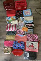 Photo showing 20 assorted cosmetic bag holders in various colors, patterns, and shapes laid out on floor