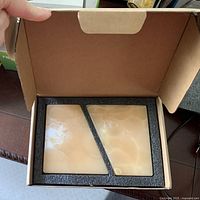 Open box with two natural onyx bookends neatly fitted into black foam inserts.