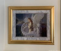 Photo of framed radiant angel art print with gold frame showing some peeling on frame.