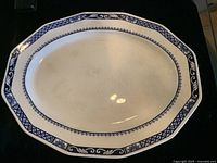 Top view of one porcelain platter with blue Delfe pattern border showing octagonal shape and some surface marks.