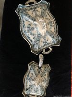 Top view of porcelain tureen with lid and large serving dish showing floral blue-green pattern on white porcelain.