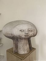 Three-quarter view of the matte white ceramic bust showing sculptural abstract head form and texture